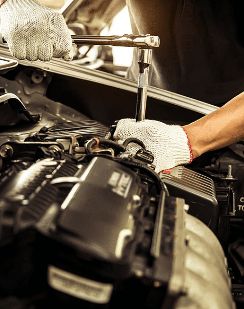 A Repair One auto technician performing engine maintenance on a vehicle