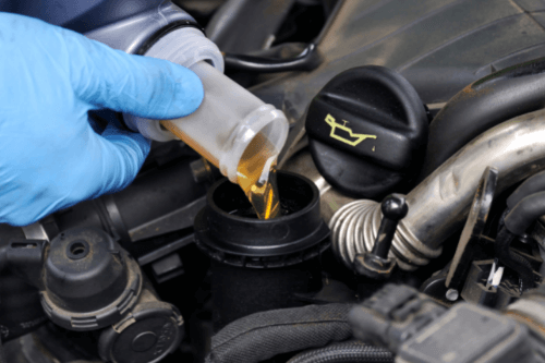 How Do I Know My Vehicle Needs an Oil Change in The Woodlands, TX? with Repair One Auto. Close up image of mechanic pouring oil into engine