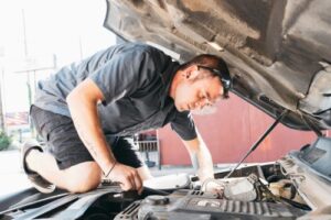 Top 3 Most Expensive Auto Repair & How to Avoid Them | Auto repair and maintenance by Repair One in Klein, TX. Image of a man looking at his car engine.