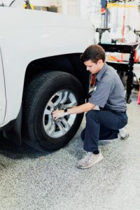 Summer Tires vs. All-Season Tires: Choosing the Best Tires in Klein, TX | Repair One. Image of a car mechanic changing tires.