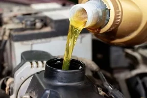 Conventional vs. Synthetic Oil | Repair One in The Woodlands, TX. Image of fresh synthetic oil poured into a car engine.