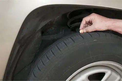 How to Know If You Need New Tires This Fall | Repair One Auto in Spring, TX. Image of a penny being used to measure tire tread depth. Lincolns head is completely exposed indicating that this tire is no longer safe and needs to be replaced.