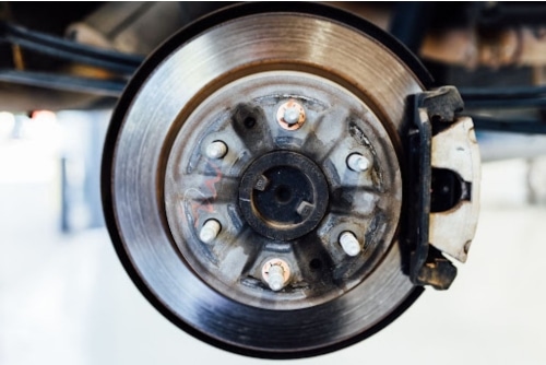 Brake Noise Solutions at Repair One, Spring, TX | Expert Brake Service. Closeup image of worn brakes on car in shop
