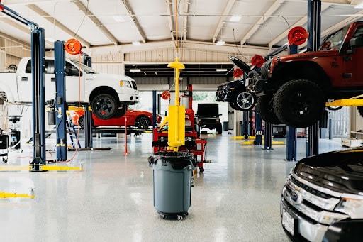 Auto care tips for Klein, Spring and Louetta, TX residents near me with Repair One. Image of vehicles on lifts in the shop for auto repair and maintenance services.