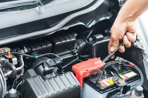 Top Signs It’s Time for a New Car Battery - Repair One The Woodlands, TX. Image of mechanic securing a new car battery on a vehicle in the shop.