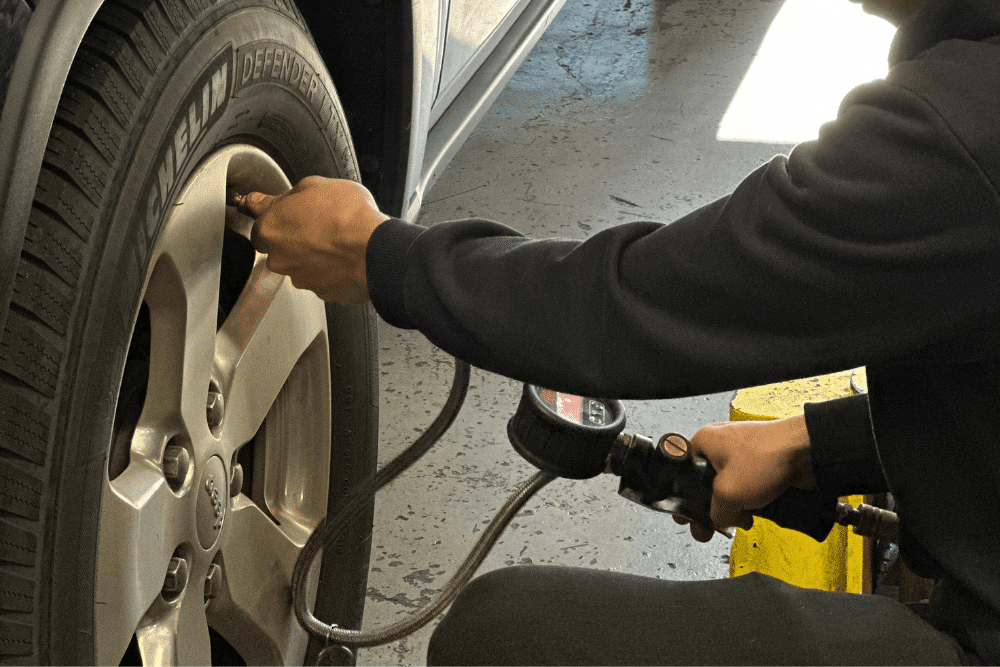 Blog 2 oil change and tire services, auto repair in The Woodlands, TX at Repair One Tire & Auto. An image of a technician checking and adjusting tire pressure on a vehicle.