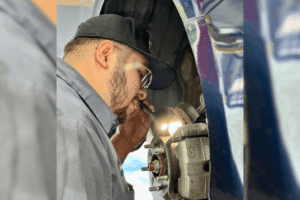 Why Texas Drivers Should Check Their Brakes Before Spring Rain Hits 2 Brake inspection, auto repair in The Woodlands, TX by Repair One Tire & Auto. Image of a technician closely inspecting a brake rotor and caliper with a flashlight, highlighting thorough brake diagnostics and maintenance to ensure safe, reliable stopping performance.